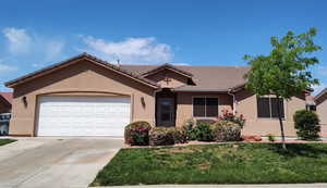 Ranch-style home featuring stucco siding, a garage, concrete driveway, and a tiled roof