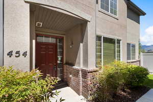 View of exterior entry with stucco siding and brick siding