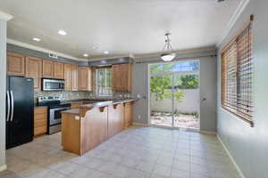 Kitchen featuring appliances with stainless steel finishes, a peninsula, tasteful backsplash, healthy amount of natural light, and a textured ceiling