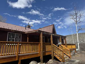 Front of property featuring metal roof and a wooden deck