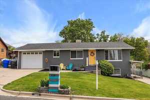 View of front of property featuring driveway, a garage, and brick siding