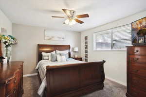 Carpeted bedroom with baseboards and ceiling fan