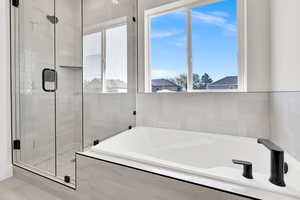 Full bath with a bath and a stall shower