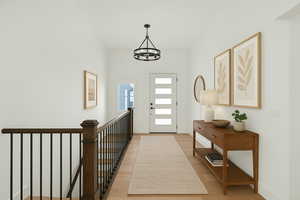 Entryway with light wood-style flooring, baseboards, and a chandelier