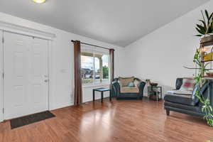Entryway featuring wood finished floors, lofted ceiling, and baseboards