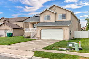 View of front of property with stucco siding, driveway, an attached garage, solar panels, and roof with shingles