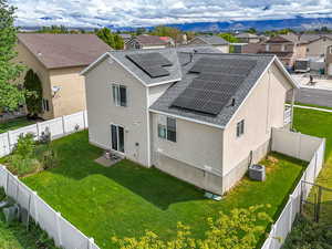 Back of property with roof with shingles, a residential view, roof mounted solar panels, and central air condition unit