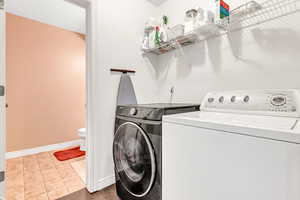 Washroom featuring separate washer and dryer and baseboards