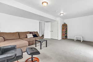Carpeted living area featuring baseboards