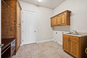 Laundry room featuring electric dryer hookup, gas dryer hookup, hookup for a washing machine, cabinet space, and baseboards