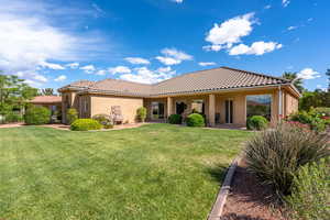 Rear view of house featuring a tile roof and stucco siding
