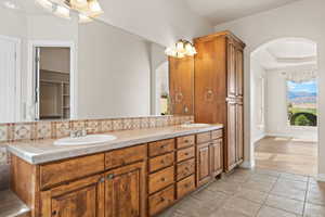 Full bath featuring tasteful backsplash, tile patterned flooring, and double vanity