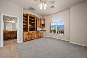 Unfurnished living room with a ceiling fan, baseboards, and a sink