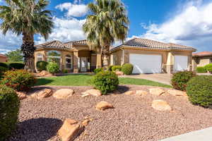 Mediterranean / spanish-style home with stucco siding, stone siding, a garage, a tiled roof, and concrete driveway