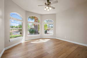 Spare room featuring baseboards, light wood-type flooring, and a ceiling fan