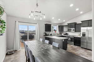Dining area with baseboards, lofted ceiling, recessed lighting, and a chandelier