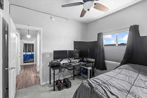 Carpeted bedroom featuring a ceiling fan