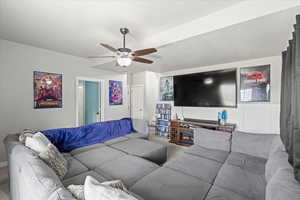 Carpeted living room with a ceiling fan