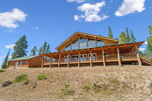 Back of property featuring a wooden deck and faux log siding