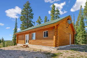 View of front of property with log siding and metal roof