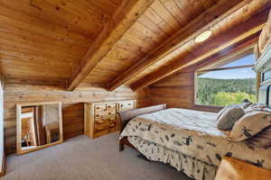 Bedroom featuring rustic walls, carpet, and wooden ceiling