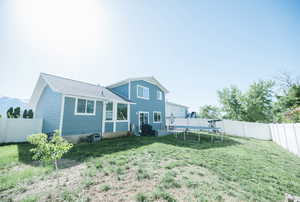 Rear view of house featuring a trampoline