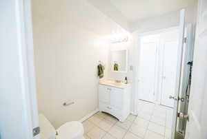 Bathroom featuring tile patterned floors, vanity, toilet, and baseboards