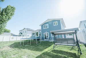 Rear view of property featuring a trampoline