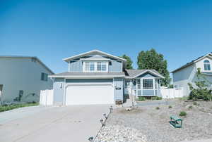 View of front of property with driveway, fence, a garage, and board and batten siding