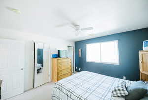 Bedroom with light colored carpet and a ceiling fan