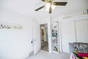 Bedroom featuring light carpet, a closet, and a ceiling fan