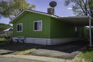 View of home's exterior featuring an attached carport and asphalt driveway