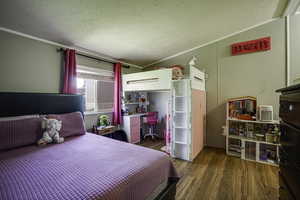 Bedroom featuring wood finished floors and ornamental molding