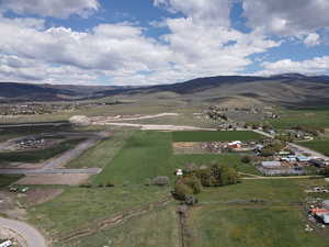 Aerial overview of property's location with a mountainous background and nearby suburban area