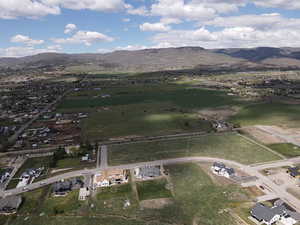 Aerial overview of property's location with a mountainous background and nearby suburban area