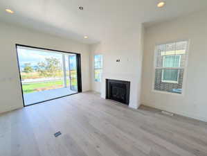 Unfurnished living room featuring recessed lighting, light wood-style flooring, and a fireplace