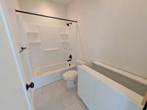 ADU-Full bathroom featuring washtub / shower combination, light tile patterned floors, and vanity