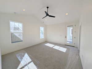 Primary room with carpet flooring, plenty of natural light, vaulted ceiling, and recessed lighting