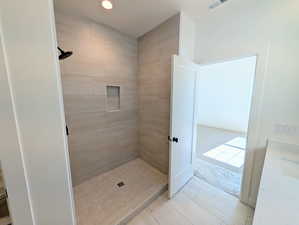 Primary Full bath featuring tiled shower and recessed lighting