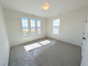 Carpeted spare room with baseboards