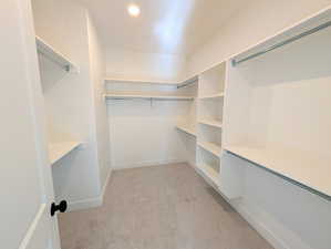 Primary Walk in closet featuring light carpet