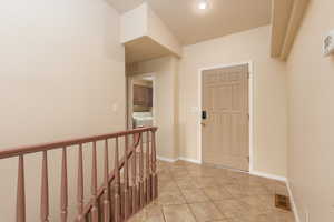 Foyer with washer / clothes dryer, light tile patterned floors, baseboards, and recessed lighting