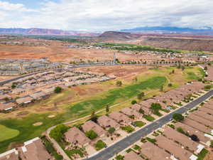 Aerial view of property's location with nearby suburban area, mountains, and a golf club