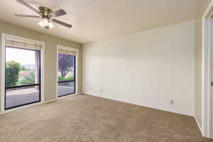 Spare room with carpet flooring, baseboards, a textured ceiling, and a ceiling fan