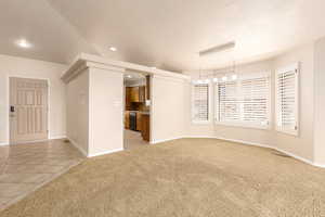 Spare room featuring light carpet, a textured ceiling, recessed lighting, baseboards, and light tile patterned flooring