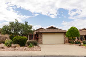 Ranch-style house with an attached garage, driveway, brick siding, and a tiled roof