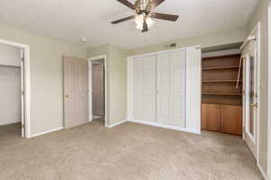 Unfurnished bedroom featuring carpet flooring, a textured ceiling, baseboards, and ceiling fan