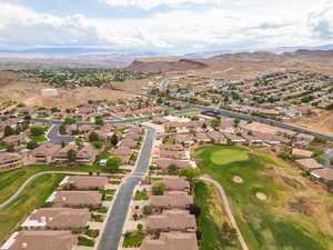 Aerial view of property and surrounding area with nearby suburban area, mountains, and a local golf course