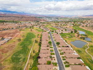 Aerial overview of property's location featuring nearby suburban area, a water and mountain view, and a golf club