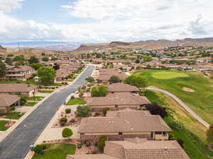 Aerial perspective of suburban area with a mountainous background and golf course